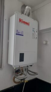 Técnico realizando manutenção preventiva em aquecedor a gás.